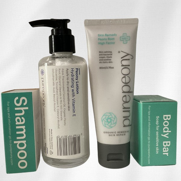 calm and restore dry itchy eczema skin with a peony lotion in a glass jar and peony root eczema cream in a large sugarcane tube and solid boxed shampoo and soap bars