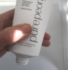 smaller size of the peony moistursier tube uncapped and held