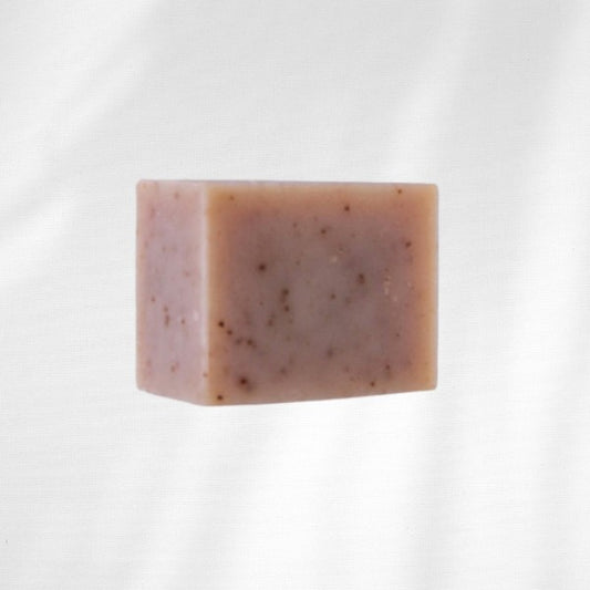 Rectangular bar of soap with peony root on a white background