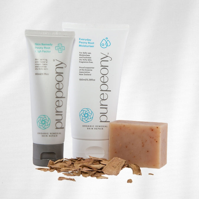 Two tubes of 'purepeony' skincare products and a bar of soap on a white background