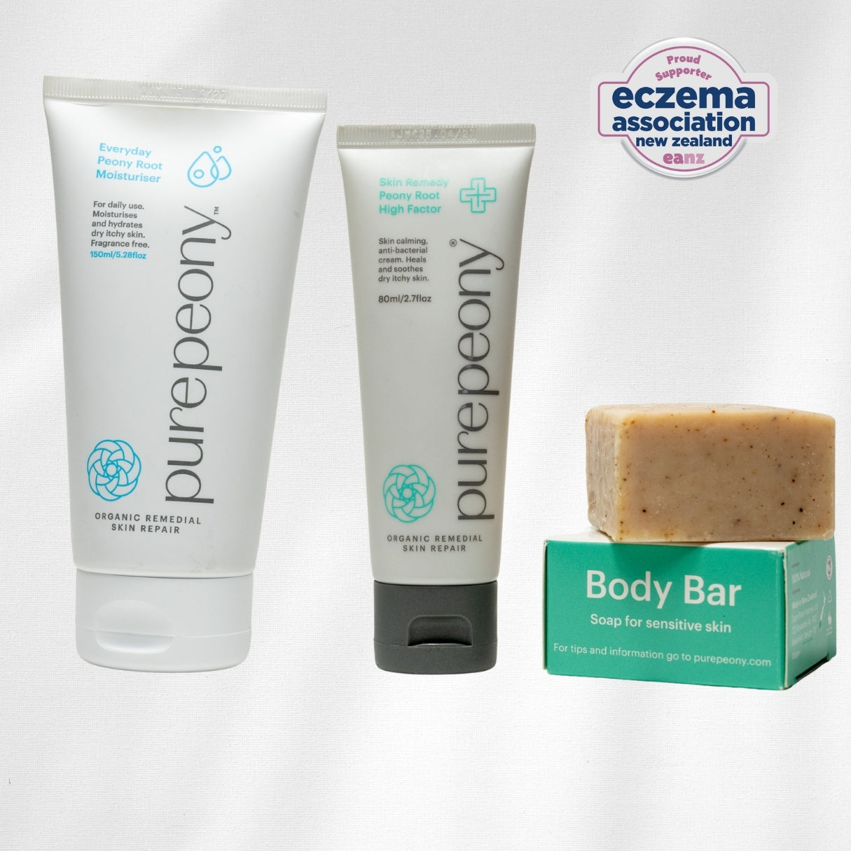 Eczema approved purepeony skincare moisturiser and treatment cream and a body bar with a box on a white background.